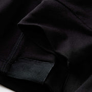 Close up detail shot of the sleeves and tag of a black lounge hoodie.