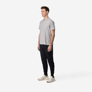 Side view full body shot of man wearing black cloud pant with grey t-shirt.