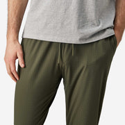 Close up front view shot of man wearing olive lounge pant.