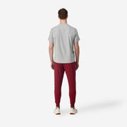 Full body back view of man wearing burgundy lounge pants.