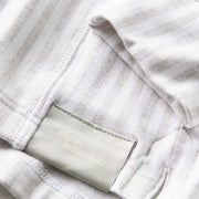 Close up detail shot of the sleeves and tag of a linen stripe lounge hoodie.