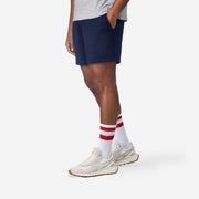 Side view of mean wearing navy blue lounge short with hand in pocket.