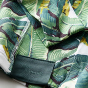 Close up detail shot of the sleeves and tag of a palms print hoodie.