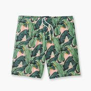 Pink mesh lounge shorts with palm leafs printed in green laid on gray background.