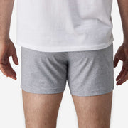 Close up back view of man wearing heather grey slim fit boxers and white t-shirt.
