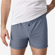 Front view close up shot of man wearing blue herringbone slim fit boxers and white t-shirt.