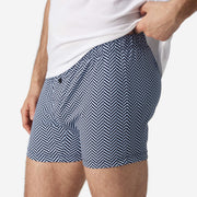 Close up side view of man wearing blue herringbone slim fit boxer and white t-shirt.