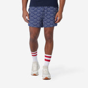 Front view of man wearing blue lounge shorts with sunrise pattern.