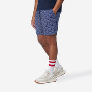 Side view of man wearing blue lounge shorts with sunrise pattern.