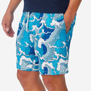 Close up side view of man wearing blue and white wave printed lounge shorts with hand in pocket.