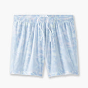 Pair of white/purple pastel dash printed lounge short sitting on light grey background.