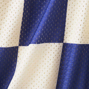 Close up detail shot of half checkered half solid blue and white mesh lounge shorts.
