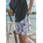 Close up of man on boat wearing dark navy blue shirt and blue plaid print madras lounge short
