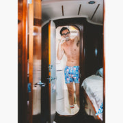 Shirtless man brushing teeth in boat bathroom wearing Blue Madras Slim Fit Boxers