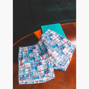 Pair of Blue Madras slim fit boxers on table next to books.