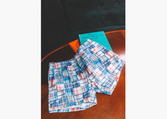 Pair of Blue Madras slim fit boxers on table next to books.