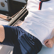 Person wearing a white shirt with blue shorts on a boat