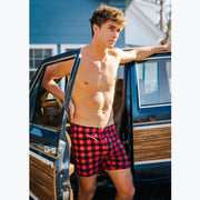 Shirtless man standing in front of a wagoneer wearing red/black buffalo plaid slim fit boxers.