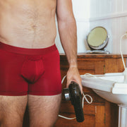Close up shot of shirtless man in bathroom wearing burgundy boxer briefs