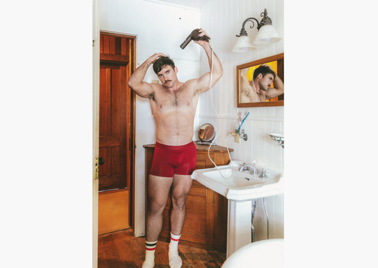 shot of shirtless man in bathroom wearing burgundy boxer briefs