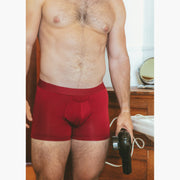 shot of shirtless man in bathroom wearing burgundy boxer briefs