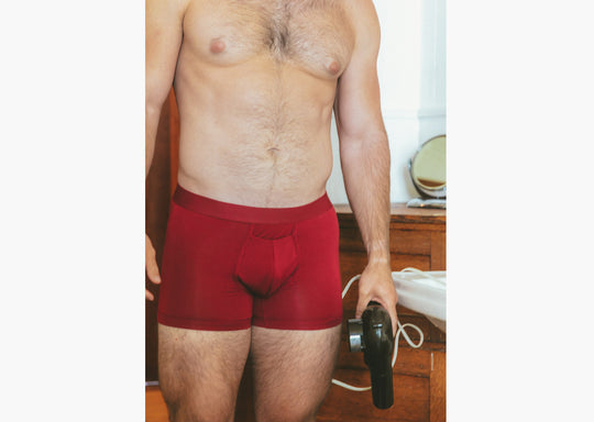 shot of shirtless man in bathroom wearing burgundy boxer briefs