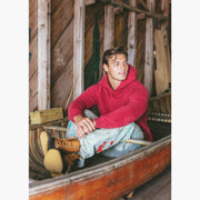Man sitting in canoe wearing burgundy hoodie