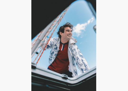 Shot of man standing on boat wearing burgundy vintage ringer t shirt