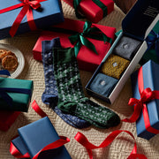 Festive layout of monogram boxes and frost and evergreen dress socks.