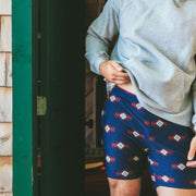 Man wearing Cabin Club lounge shorts and grey hoodie standing in doorway