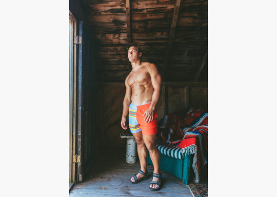 Man in boathouse wearing Canoe Stripe lounge shorts.