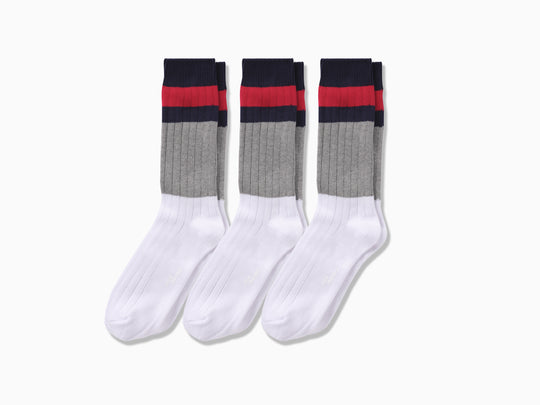 3 pairs of White, grey, blue and red striped chunky knit socks laid flat on light grey background.