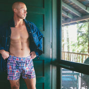 Man standing in doorway wearing denim jacket and classic madras slim fit boxers 