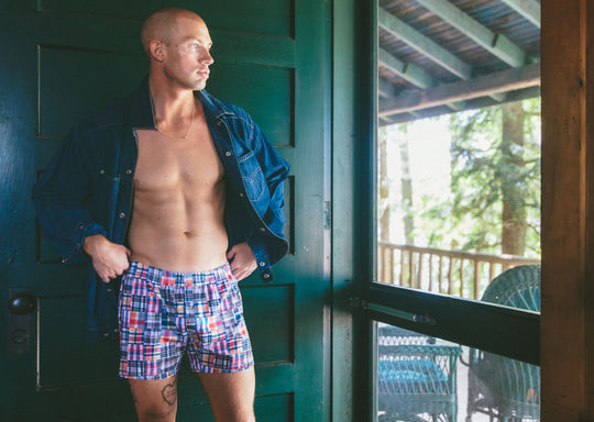 Man standing in doorway wearing denim jacket and classic madras slim fit boxers 