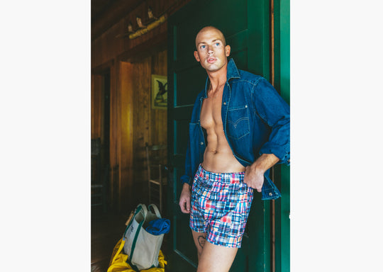 Man standing in doorway wearing denim jacket and classic madras slim fit boxers 