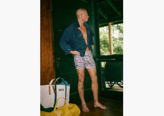 Man standing in doorway wearing denim jacket and classic madras slim fit boxers 