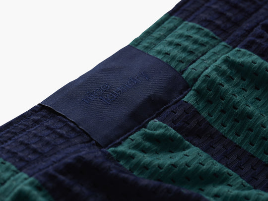 Close up of back label found on green/navy stripe lounge shorts