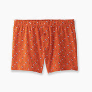 A pair of orange Doghouse slim fit boxers sitting flat on light grey background. Boxers have doghouse, golf clubs, and cards printed in small repeating pattern.