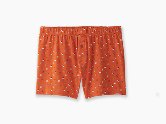 A pair of orange Doghouse slim fit boxers sitting flat on light grey background. Boxers have doghouse, golf clubs, and cards printed in small repeating pattern.