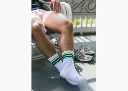 Close up shot of man resting in white chair wearing fieldhouse crew stripe socks and pink slim fit boxers.