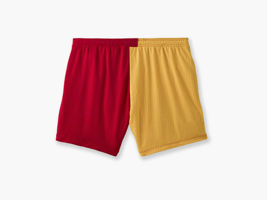 Close up shot of multi colored mesh "fun short" on a light grey background. Back colors are Yellow and Red.