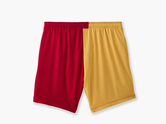 Back shot of multi colored (blue, green, yellow and red) mesh lounge shorts with red drawstrings laid flat on light grey background.
