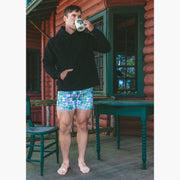 Man standing drinking coffee and wearing black hoodie and green madras slim fit boxer