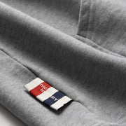 Close-up of a gray fabric with a brand label featuring red, white, and blue colors.