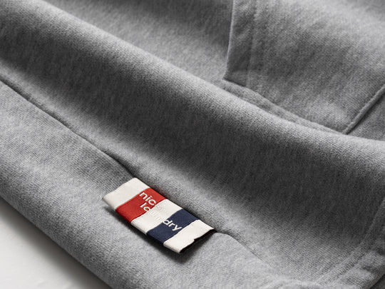 Close-up of a gray fabric with a brand label featuring red, white, and blue colors.