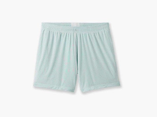 Pair of white mesh lounge short with light green interior laid flat on grey background.