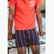 Man leaning against bed railing wearing red saint davids athletics shirt and blue/red Mariner slim fit boxers.