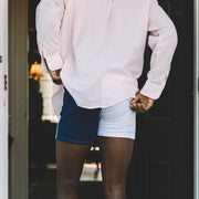 Photo from behind of man walking into house door wearing Color Block Blues slim fit boxer and dress shirt .