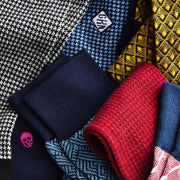 Macro detail texture shot of various monogrammed dress socks in cubes, houndstooth and tile patterns.