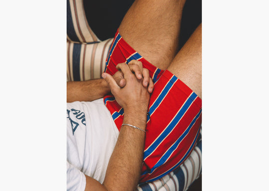 Close up shotof man wearing red/blue/yellow stripe slim fit boxers.